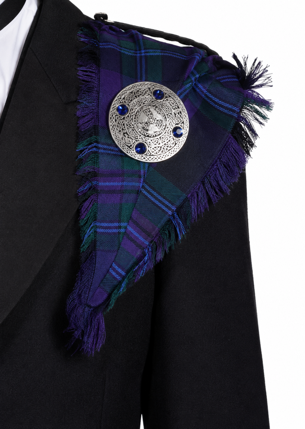 Close-up of a purple, blue and green tartan fringed fly plaid secured at the shoulder with a decorative silver-tone plaid brooch.
